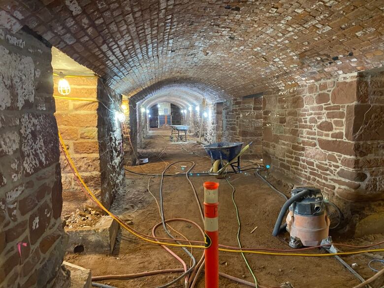 Interior hallway of very old stone building with construction materials.