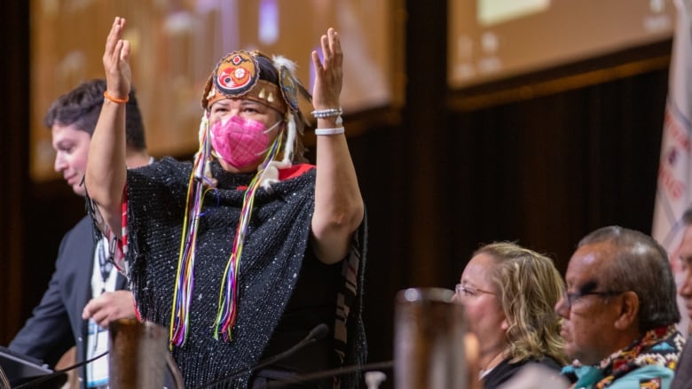 A politician rises with her hands in the air.