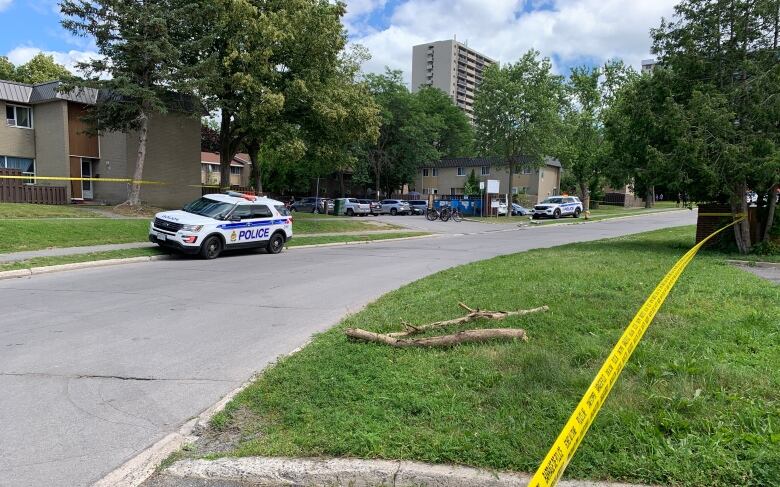 Police tape surrounds a crime scene in a residential neighbourhood.