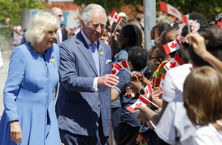 Two people meet children waiting to see them.