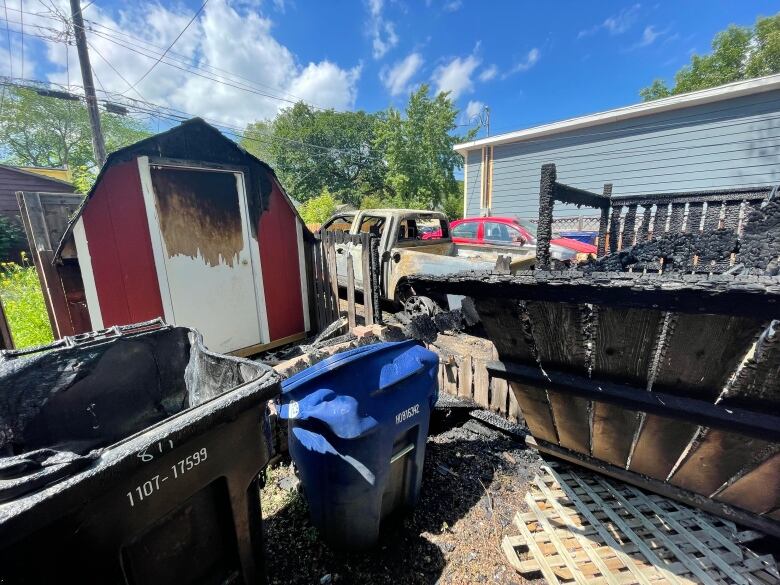 A shed and fence damaged by fire.