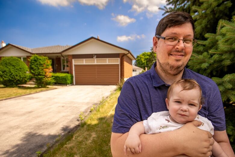 Tim Capes, shown here holding his infant son Ben, owns a home in Markham Ontario. He had a variable rate mortgage on the property, but he recently decided to switch to a fixed-rate loan because he's worried interest rates are set to rise quickly.