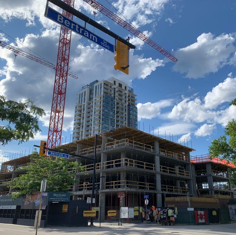 Cranes rise above the construction site where five men were killed in a crane collapse in Kelowna, B.C., on July 12, 2021. A memorial to those who lost their live can be seen on the fencing of the site. July 11, 2022.