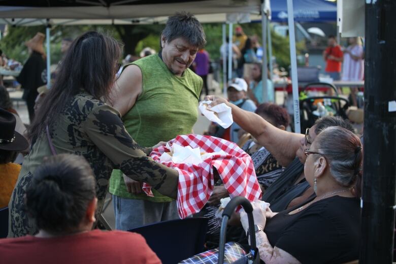 Fry-bread is given out to attendees at a memorial vigil held in honour of Lyackson First Nation member and Indigenous rights activist Kat Norris, in Grandview Park, Vancouver on Tuesday, July 12, 2022.