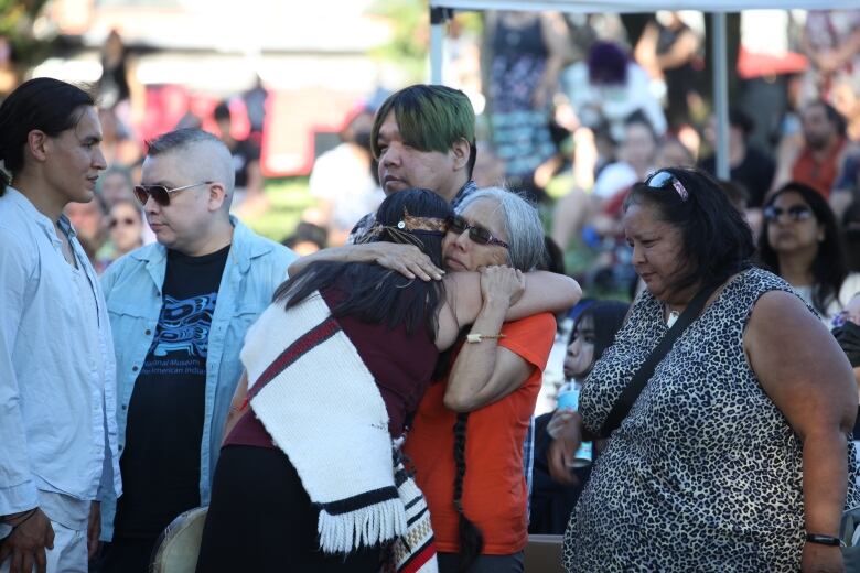 Family members of Lyackson First Nation member Kat Norris receive hugs and greetings from attendees at a vigil in Norris' memory on Tuesday in Grandview Park, Vancouver. 