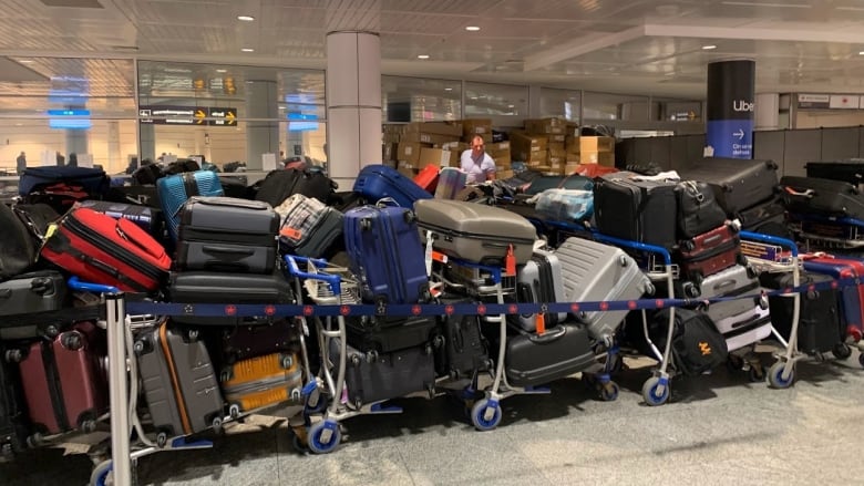 Dozens of suitcases and other luggage sit stacked up in Montreal airport.