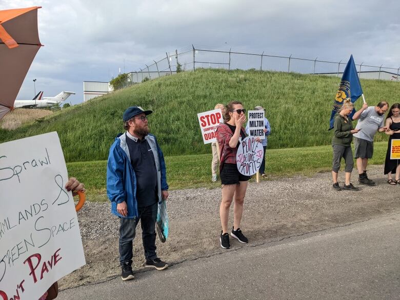 People stand and hold signs