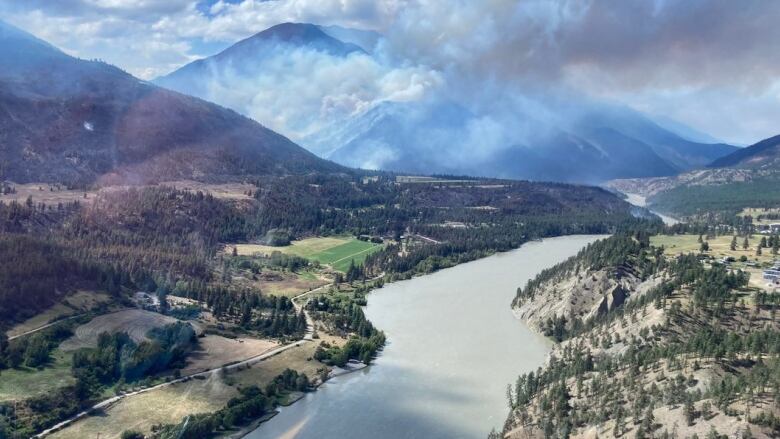 The Nohomin Creek wildfire and local river is seen in an aerial photograph 1.7 km northwest of Lytton B.C. on Saturday, as smoke rises in the mountainous distance.