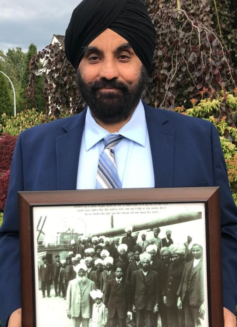 Man holding a framed photograph.