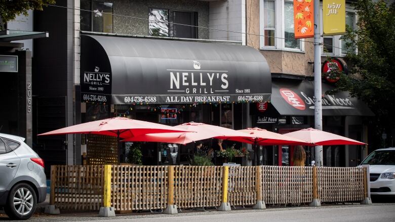 The Nelly's Grill storefront. It has a black awning, which reads 'ALL DAY BREAKFAST' in small text.