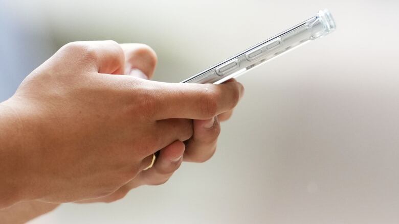 A close-up of someone typing on a cell phone.