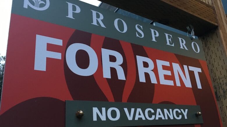 A sign that reads 'FOR RENT No Vacancy' in white font on a red sign.