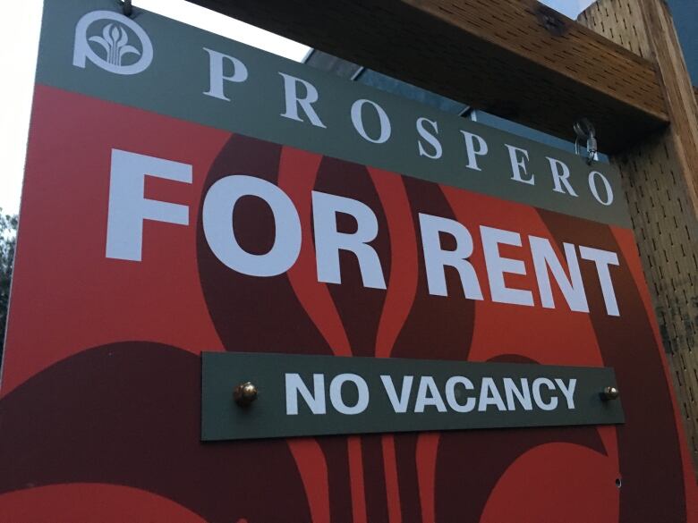 A sign that reads 'FOR RENT No Vacancy' in white font on a red sign.