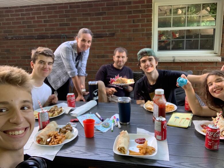 Omstead-Egglezos family sit around a table eating dinner after the kidney donation.