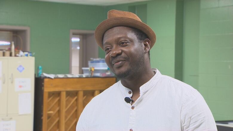 A Black man wearing a fedora and a white button up