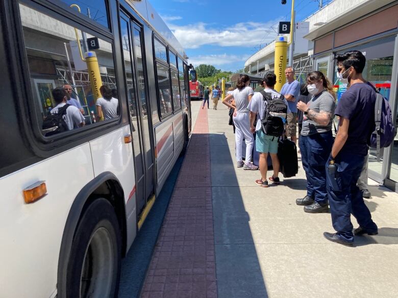 A lineup waits for the bus.