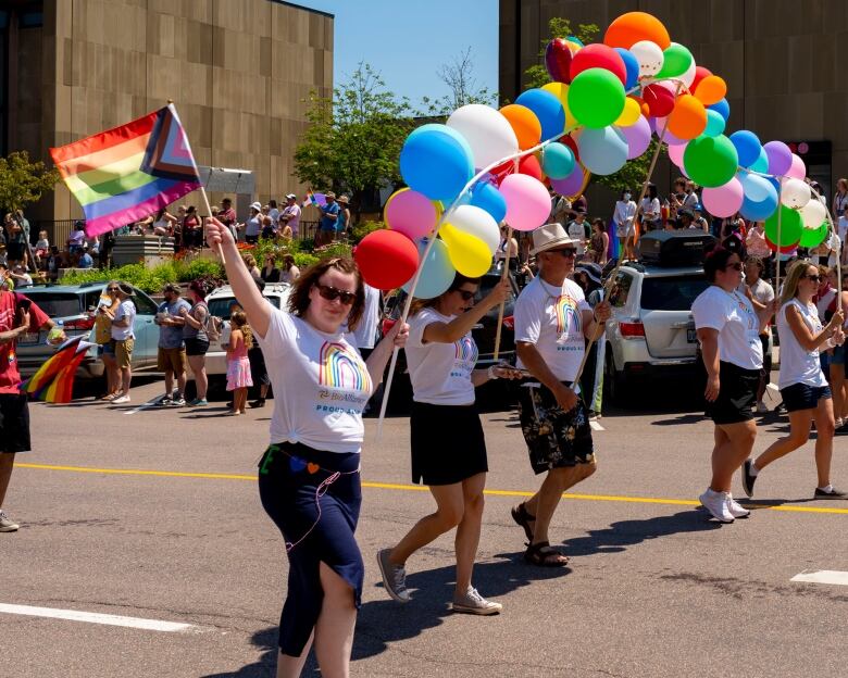 people holding a banner of balloons