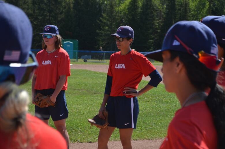 Malaika Underwood (centre), who plays first base for the American national women's baseball team, listens to her coaches during a practice in Thunder Bay, Ont., ahead of an international friendly series against Canada.