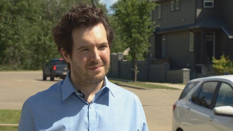 An Edmonton homeowner stands on a residential street.