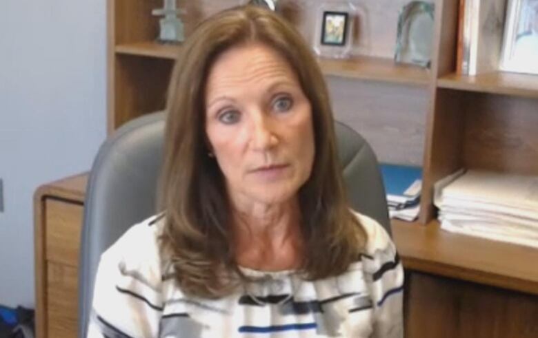 A woman sits in an office. 