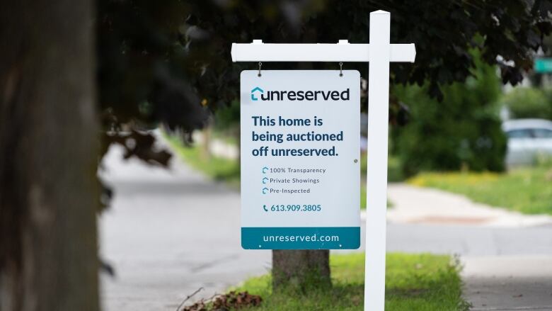 A sign in front of a home for the Unreserved service, saying the home is being auctioned.