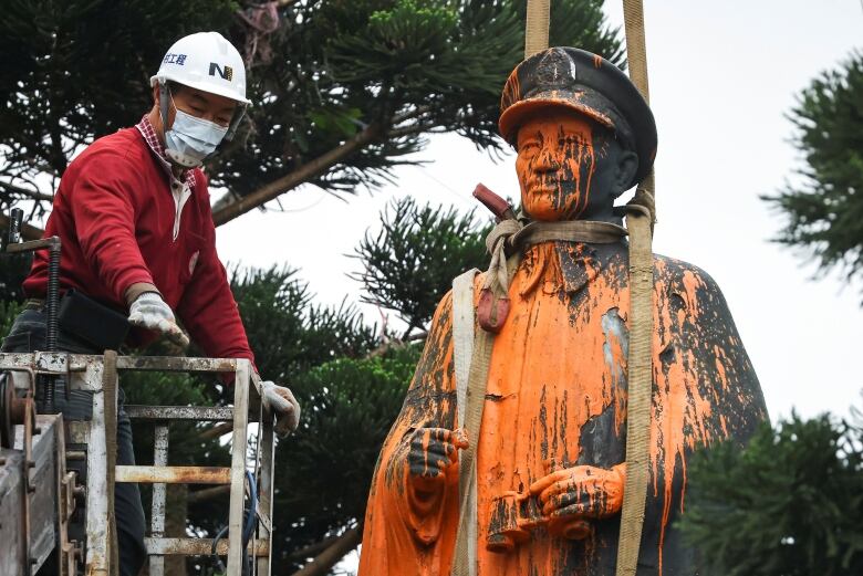 A worker dismantles a vandalised statue of late Taiwan President Chiang Kai-shek in Keelung, Taiwan March 3, 2021.