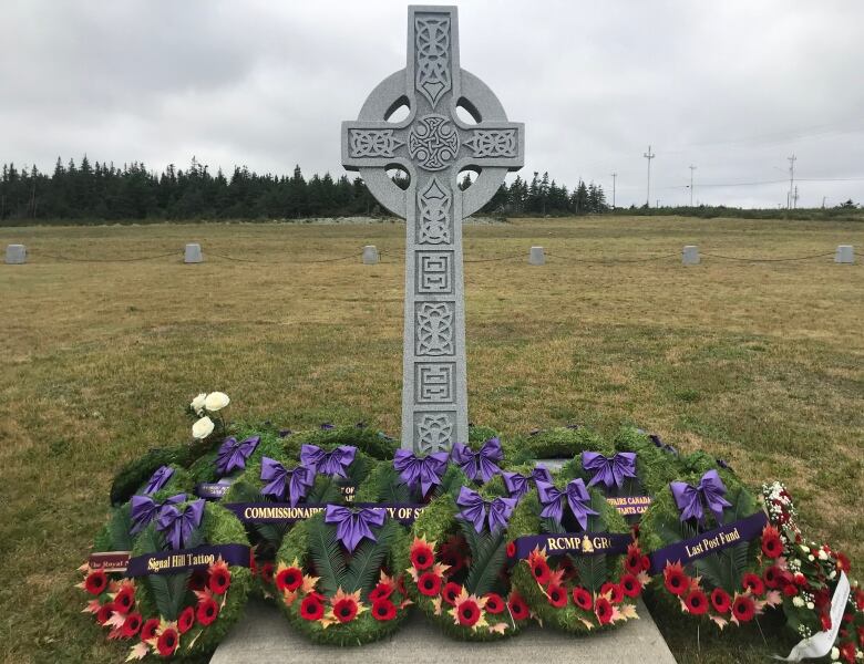 A cross with military wreaths laid beneath it shows the Field of Honour memorial. 