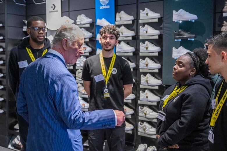 A person talks with other people in a shoe store.