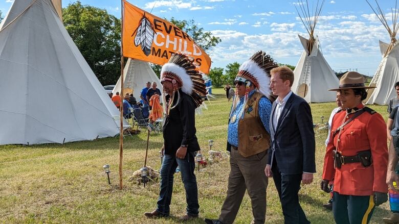 Edwin Ananas, David Pratt and Marc Miller walk in a row with a orange 