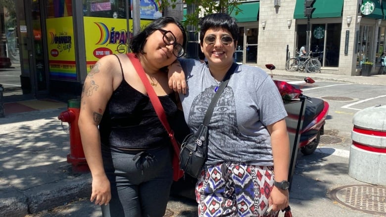 Two people stand on a street