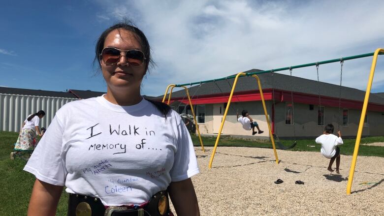 A woman is wearing a white T-shirt with the words 