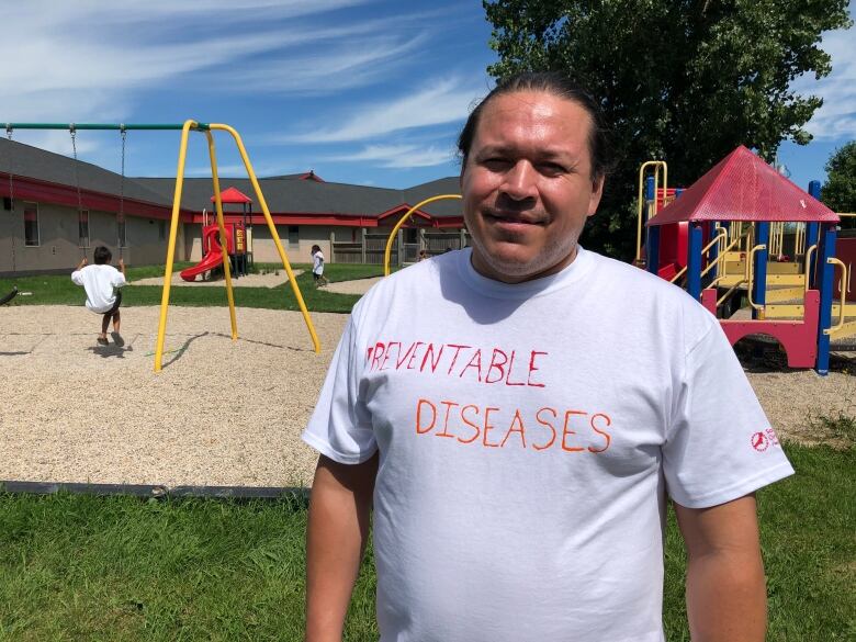 A man is wearing a white T-shirt with the words 