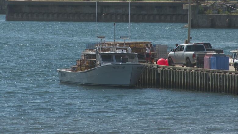 Fishing boat lies alongside a wharf. 