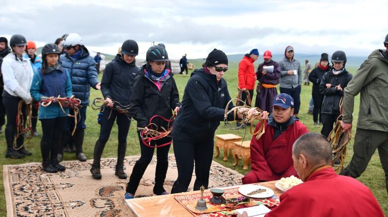 People line up with gear during the Mongol Derby