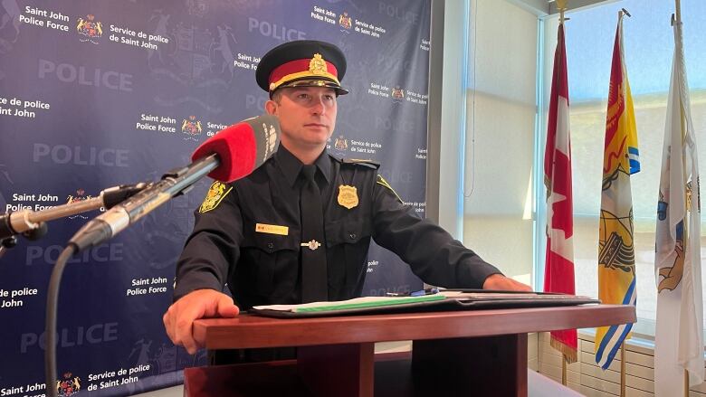 police officer in full dress uniform standing at a podium.