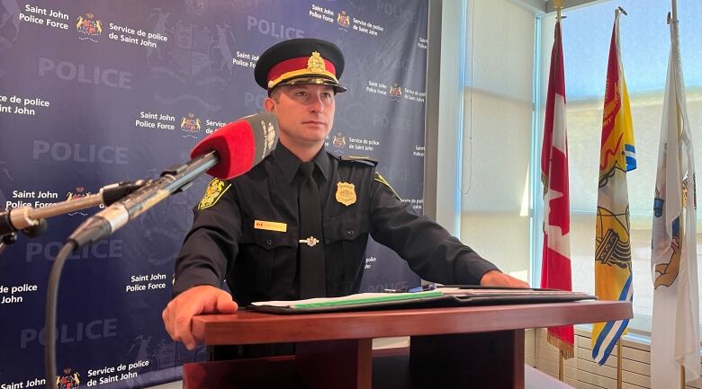 police officer in full dress uniform standing at a podium.