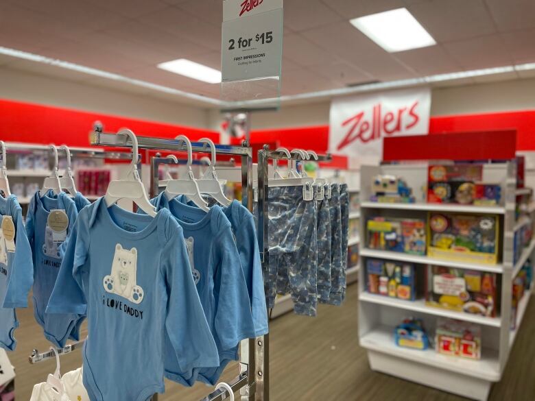 Baby apparel and toys are seen displayed alongside signage for Zellers.