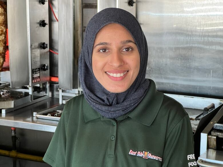 A woman wearing a hijab standing in a kitchen.