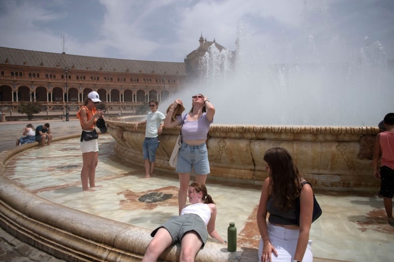 People use a public fountain to cool down.