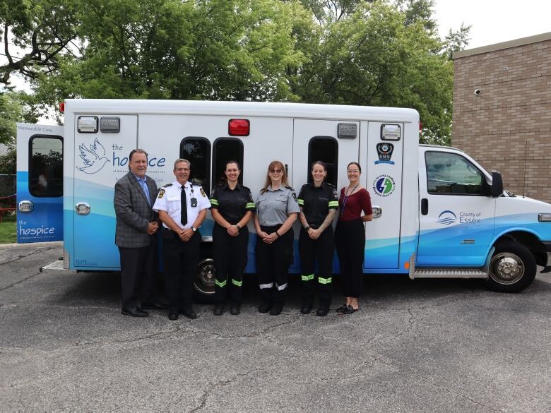 People stand in front of retrofitted ambulance