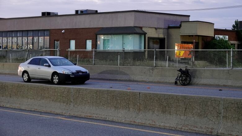 The scene following a highway collision, where a car and bent wheelchair can be seen. 