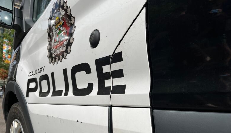 The side door of a black-and-white police cruiser.