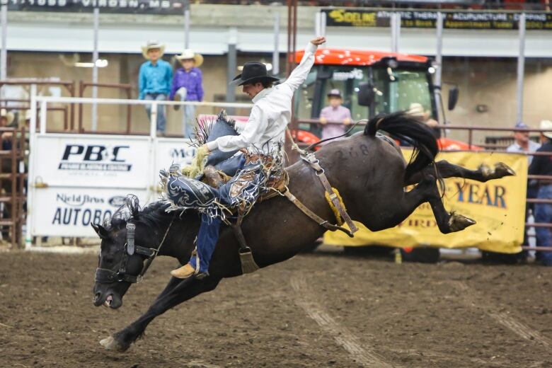 A cowboy rides a bucking bronc.