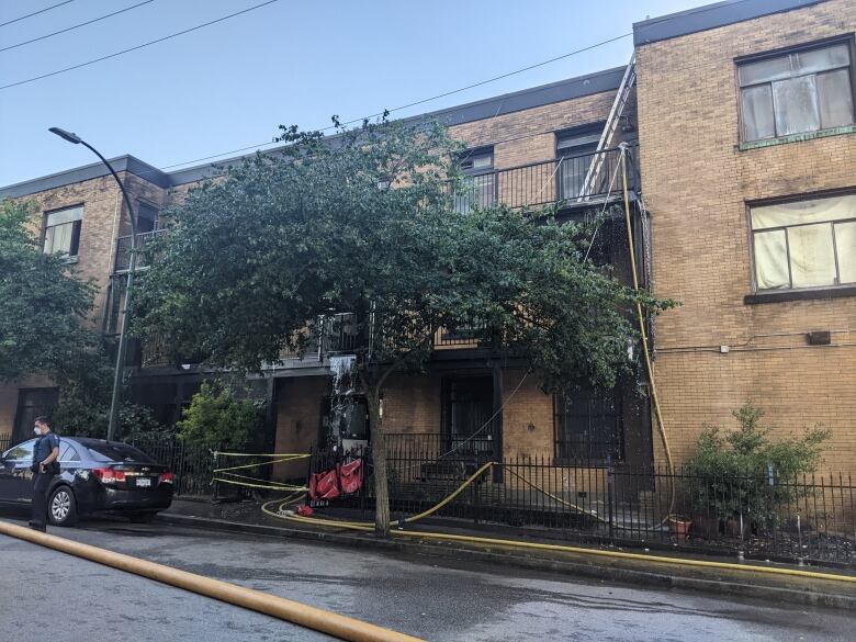 A building is shown with a fire hose out front and water pouring out of one unit.