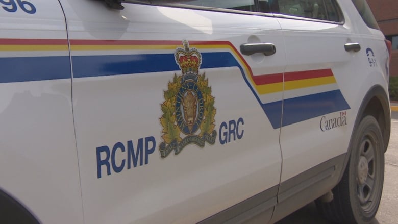 An RCMP logo is seen on the side of a police van.