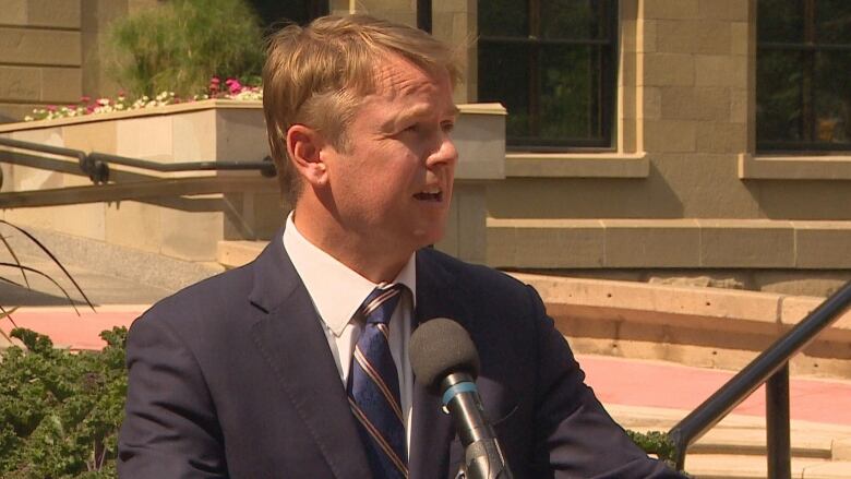 a man speaks into a microphone at a podium