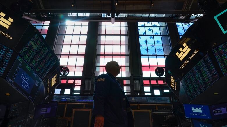 A person stands on the floor of the New York Stock Exchange.