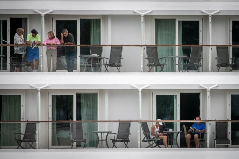 People stand on a cruise ship