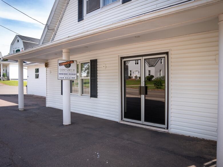 White building with real estate sign.