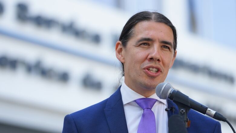 Winnipeg mayoral candidate Robert-Falcon Ouellette stands at podium to talk about the Winnipeg police budget.